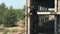 A man walks on a rope at a height on an abandoned construction site.