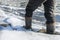 A man walks on thin ice, his feet fall through and break the edge of the ice. Danger of walking on ice in winter