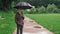 A man walks under an umbrella on a rainy day.