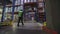 A man walks through the warehouse view from the back. A worker walks through a factory warehouse. Rear view of a worker