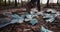 A man walks through the woods past a landfill made of household rubbish