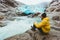 Man wanderer relaxing alone traveling at Nigardsbreen glacier in Norway