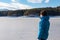 Man in warm hat breathing fresh cold air at frozen alpine lake Forstsee, Techelsberg, Carinthia (Kaernten), Austria, Europe