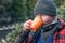 Man in a warm jacket and beanie drinking coffee