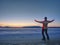 Man in warm suit gesture to morning horizon. Hiker stay on ice