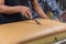 The man was cutting large bread with a knife to cut the bread.