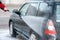 A man washes a black car with a strong jet of water at a self-service car wash