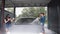 A man washes a car at a self-service car wash. A young man cleans the car with foam and water