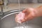 A man washes defrosted raw chicken fillet. Fresh raw chicken breast for cooking chopped chicken cutlets. A man washes