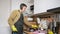 Man washes dishes dancing and listening music in headphones