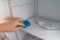 A man washes the freezer using sponge. Cleaning the refrigerator. Selective focus. Copy space.