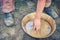 A man washes gold sand in a copper tray. Washing of gold in the tray by American pioneers in Klondike. Historical reconstruction