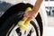 A man washes his car with foam at a self-service car wash, wheels and tires close-up