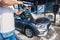 A man washes his car at a self-service car wash using a hose with pressurized water