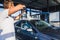 A man washes his car at a self-service car wash using a hose with pressurized water