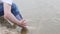 A man washes his feet in the river in summer.