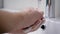 A man washes his hands in his bathroom. Men`s hands in the frame, a modern house with an automatic foam dispenser.