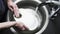 A man washes a white plate with a sponge. Home life. Slow motion video