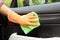 Man washing car door from inside with rag