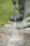 Man Washing Concrete Path With Pressure Washer