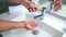 Man washing hands in bathroom sink at home checking temperature with hand