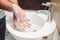 Man washing hands with soap and sanitiser in home bathroom,. details of hygiene