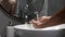 Man is washing hands with soap in sink to prevent coronavirus Covid-19 infection. Male washes hands with foam, lathering hands and