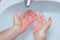 Man washing hands with soap under bathroom sink
