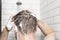 A man washing her hair with shampoo in the shower room.