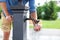 Man washing his hand in faucet water. Ð¡ity water tap with drinkable water in park. Drinking column.