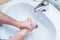 A Man is washing his hands with soap in bathroom