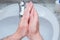 A Man is washing his hands with soap in bathroom