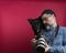 Man watching camera photos with his dog in a studio on a red background