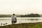 Man watching at lake of two rivers algonquin national park watching ducks Ontario Canada on a grey morning atmosphere