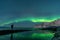 Man watching the northern lights, Aurora Borealis, Devil Teeth mountains in the background, Tungeneset, Senja, Norway