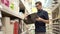 Man is watching a plastic basket in a supermarket, twirling it in hand