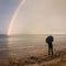 Man watching rainbow on beach