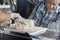 Man Watching Salesman Slicing Blue Cheese In Shop