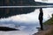 Man watching on the water of lake standing alone on the beach.