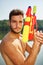 Man with a water gun standing proud at a lake
