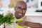 Man watering bonsai leaves