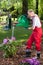 Man watering the flowers when his wife cleans lawn