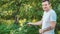 Man watering the garden from hose. Male spraying water on vegetables with a garden hose. A happy man with a hose takes