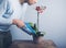 Man watering orchid with water pistol