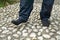 Man wearing black socks, walking on pebble stones