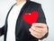 A man wearing a black suit is holding red paper heart Means of love in the month of love valentine`s day