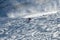 Man wearing bright red suit skiing on snowy backcountry bowl area. Extreme winter sports.