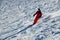 Man wearing bright red suit skiing on snowy backcountry bowl area. Extreme winter sports.