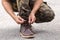 Man wearing cargo pants and tying the laces on leather shoes boot