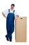 Man wearing dungarees leaning against large box